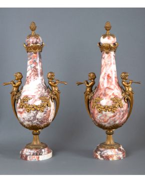 1027-Pareja de jarrones con tapa, Francia, s. XIX. En mármol blanco veteado en rosa y monturas en bronce dorado. Asas con amorcillos tocando el aulós 