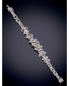 44-CLASICA PULSERA DE PEDIDA. AÑOS 50 CON FRENTE DE FLORES CUAJADAS DE BRILLANTES. Montura en oro bl