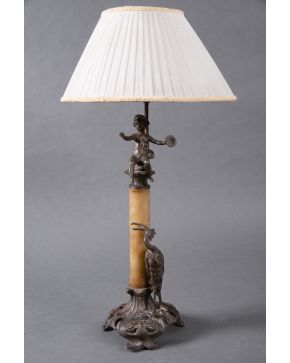 2058-Lámpara de sobremesa Art Nouveau con base en hierro con representación de ave exótica, fuste de alabastro y remate de putti.