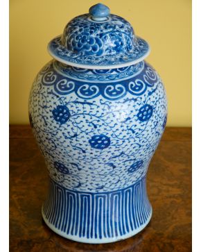 79-Tibor con tapa en porcelana china blanca y azul con profusa decoración vegetal y base rayada. 