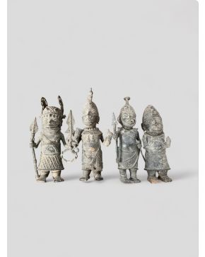 2057-Lote de cuatro guerreros africanos con tocados y armaduras, Benin, s. XX.  Bronce relevado.  Altura mayor: 40