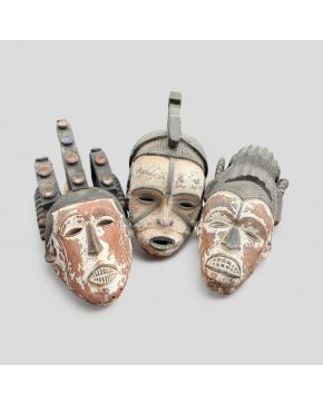 2084-Tres máscaras tipo Igbo de danza, costa occidental africana, s. XX.  Madera policromada en negro, rojo, blanco y