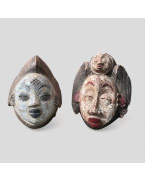 2087-Lote de dos máscaras tribales tipo Punu, Gabón, s. XX.  En madera policromada en azul, negro, rojo y blanco (cao