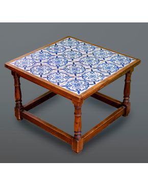 509-Mesita auxiliar en madera de nogal con patas torneadas y sobre con azulejos en cerámica de Talavera azul y blanca. 