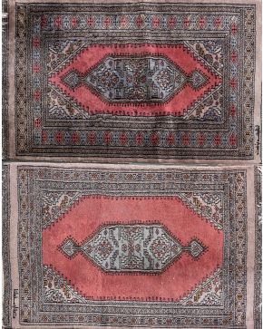 593-Dos pequeñas alfombras persa en seda y lana, tonos grises y granates. Con decoración geométrica. Medidas: 96 x 63