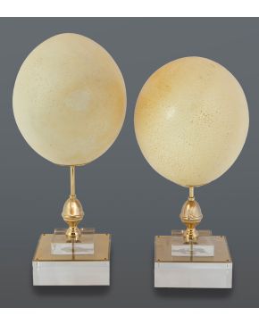 488-Pareja de huevos de avestruz con soportes contemporáneos en metal plateado y cristal.