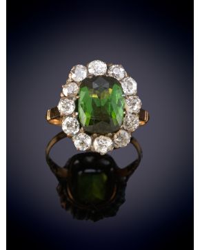 11-Sortija antigua con un peridoto central talla cojín rodeado de diamantes. Montura en oro rosa de 18k