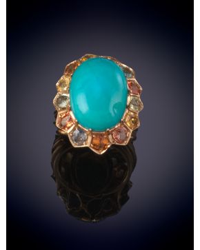 36-SORTIJA CON GRAN TURQUESA EN CABUJÓN ORLADA DE ZAFIROS. Montura en oro amarillo 14k.