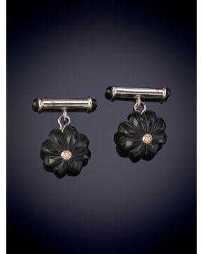 44-GEMELOS DE ONIX TALLADO EN FORMA DE FLOR Y BRILLANTE CENTRAL. Montura en oro blanco de 14k.