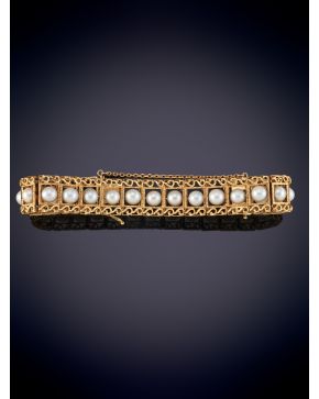 53-ANTIGUA PULSERA CON HILERA CENTRAL DE PERLAS CULTIVADAS SOBRE UNA MONTURA CALADA EN ORO AMARILLO 18K.