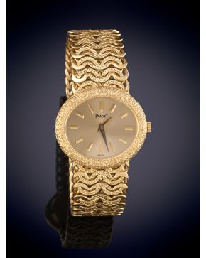 924-“PIAGET” RELOJ JOYA DE SEÑORA AÑOS 60/70 CAJA REDONDA Y BRAZALETE INTEGRADO EN ORO AMARILLO 18K. Esfera dorada satin