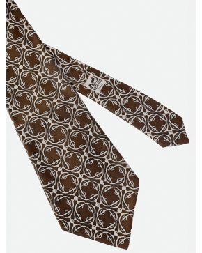 882-HERMÉS. CORBATA DE FONDO MARRON CHOCOLATE CON DIBUJO DE CELOSIAS EN COLOR BEIGE.