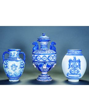 1219-Gran jarrón con tapa de Talavera. años 30. en cerámica blanca y azul esmaltada. Con cariatides en relieve y asas en forma de león. Tapa preparada para