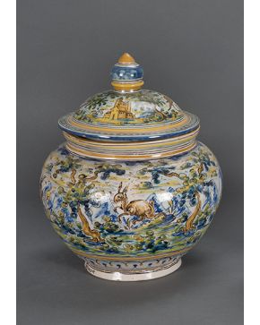 389-Gran orza con tapa en cerámica esmaltada de Talavera-Montemayor de la serie polícroma respresentando escenas con animales y arquitecturas sobre paisaj
